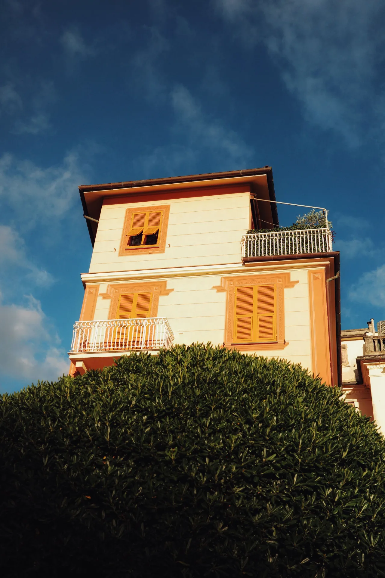 Una casa color crema e arancio sotto il cielo blu